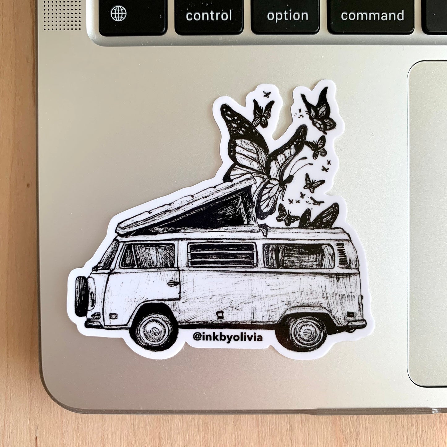 Vintage VW bus with butterflies flying out of the roof, whimsical and nature-inspired design.