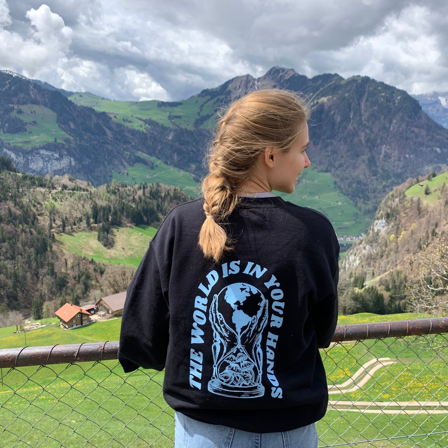 World in Your Hands sweatshirt featuring original artwork by Olivia, cozy fleece-lined design with motivational message.